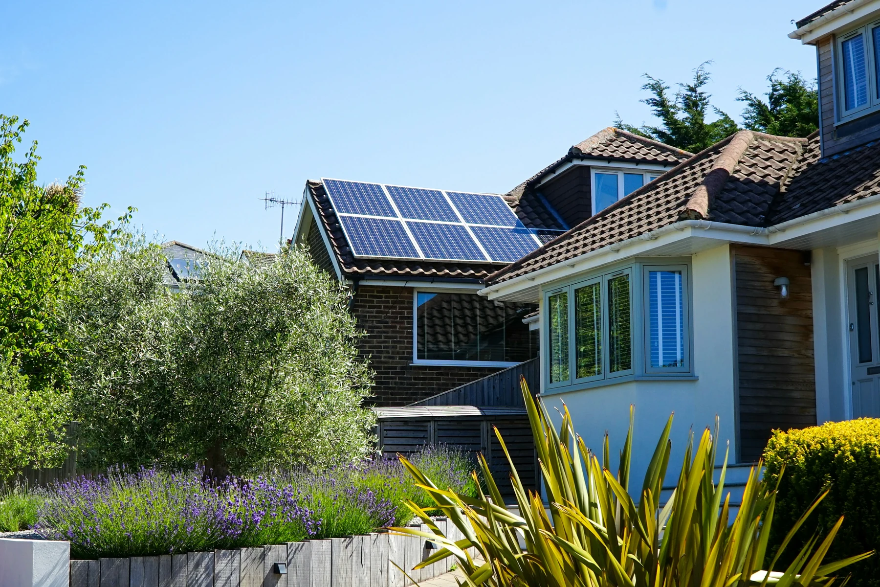 Maison individuelle entourée de verdure avec panneaux photovoltaïques sur le toit