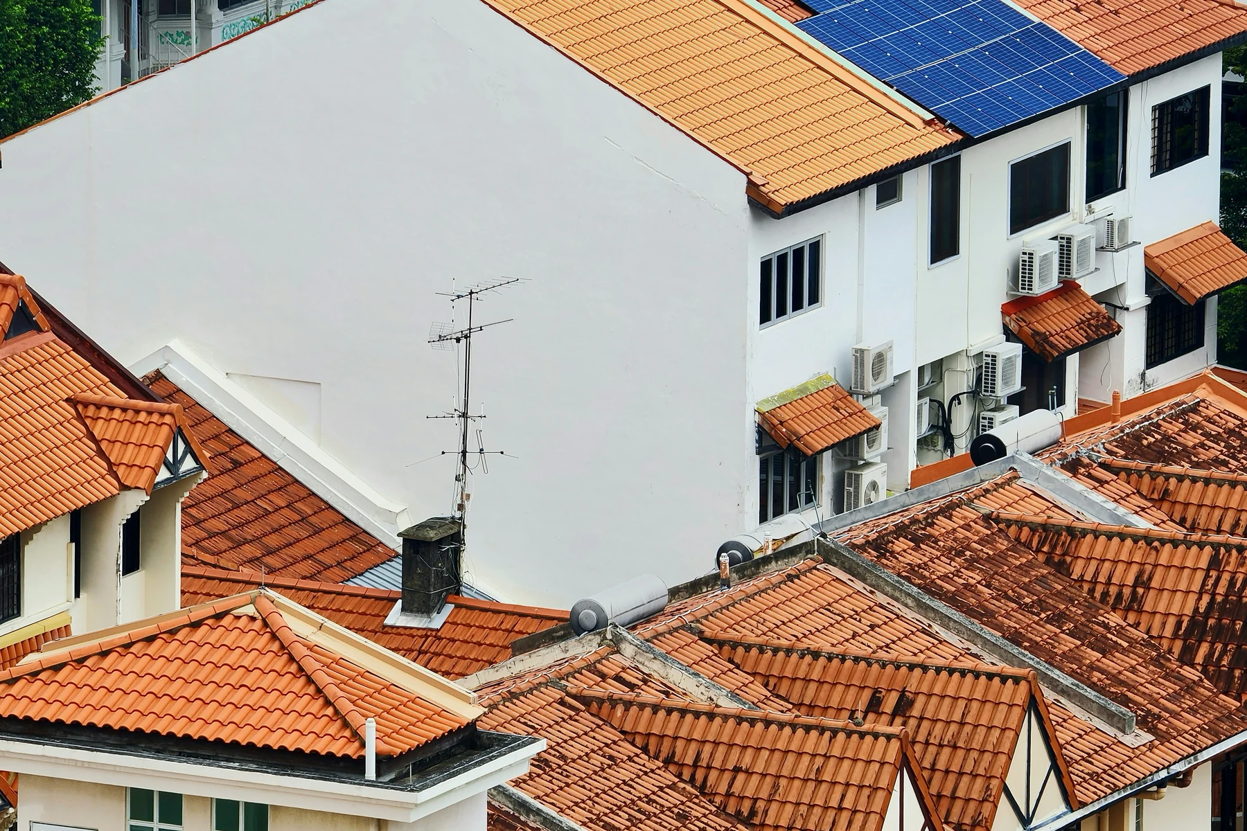 Panneaux photovoltaïques intégrés parmi plusieurs toitures résidentielles en tuiles
