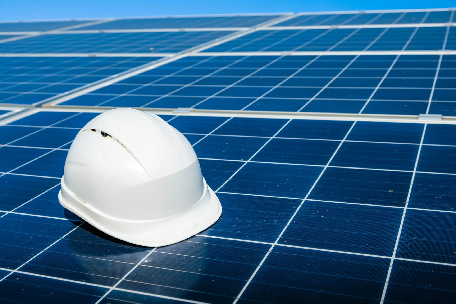Casque de chantier posé sur une rangée de modules photovoltaïques