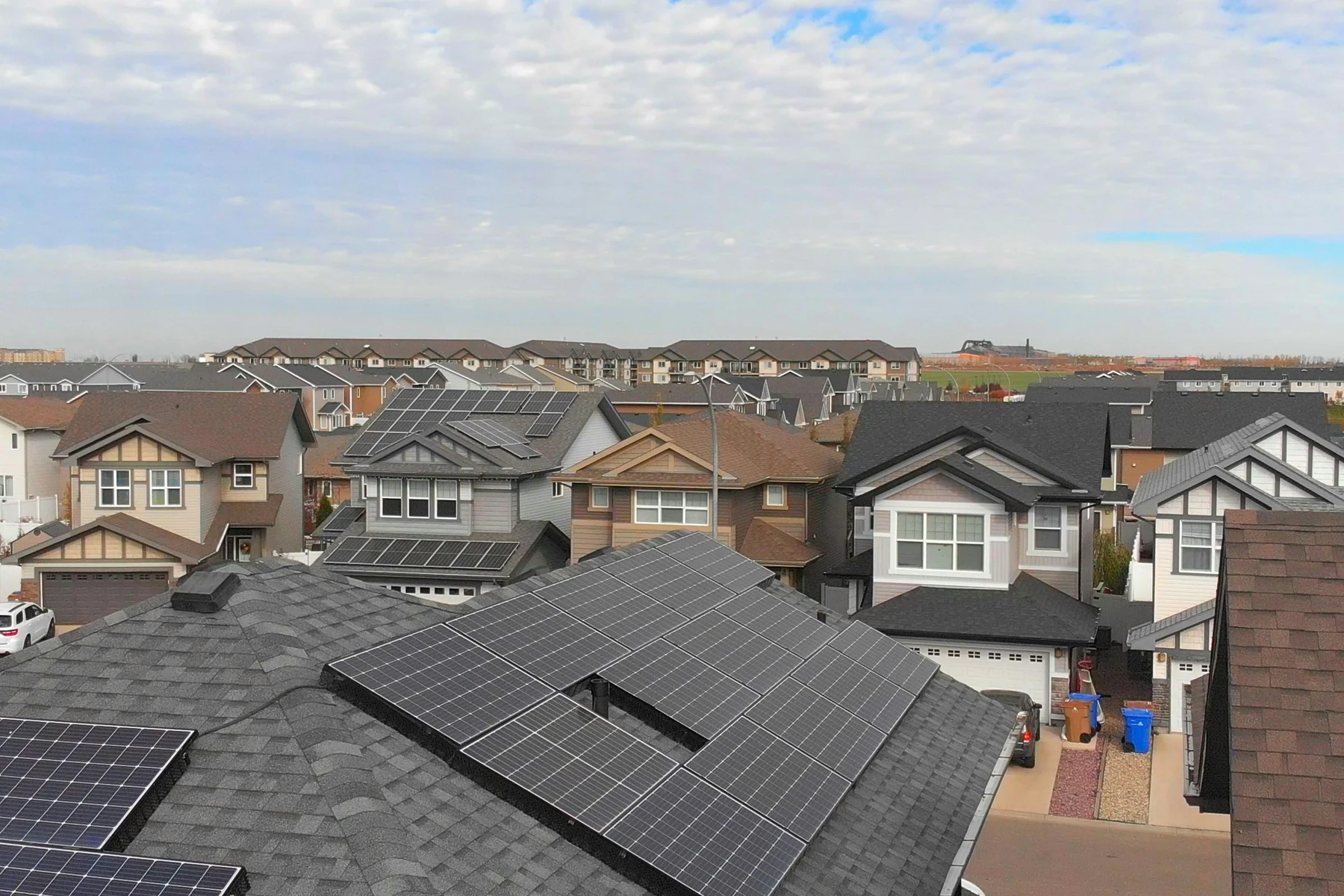 Toitures de maisons résidentielles dont l'une est équipée de panneaux photovoltaïques